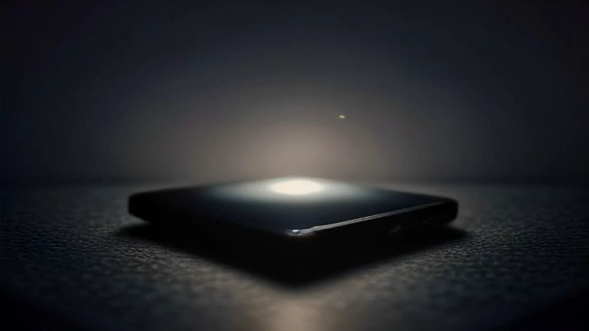 A smartphone lying on a dark desk with a softly glowing abstract chat interface